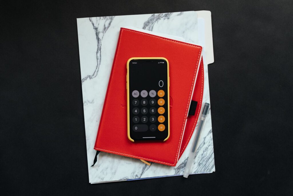dossier with red notebook and phone calculator